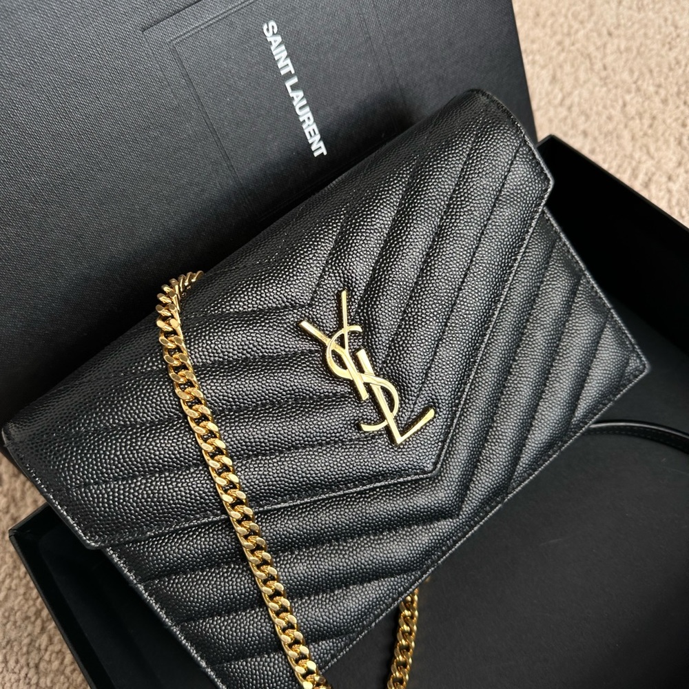 Yves Saint Laurent small black crossbody bag with gold chain.